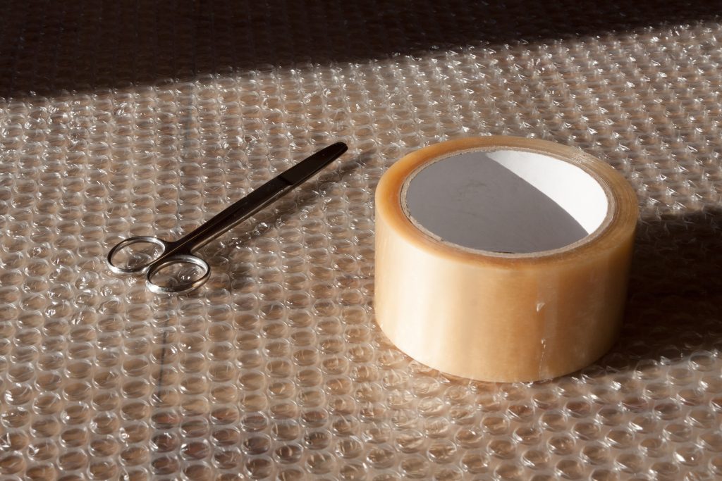 Bubble wrap, packing tape, and scissors for wrapping souvenirs