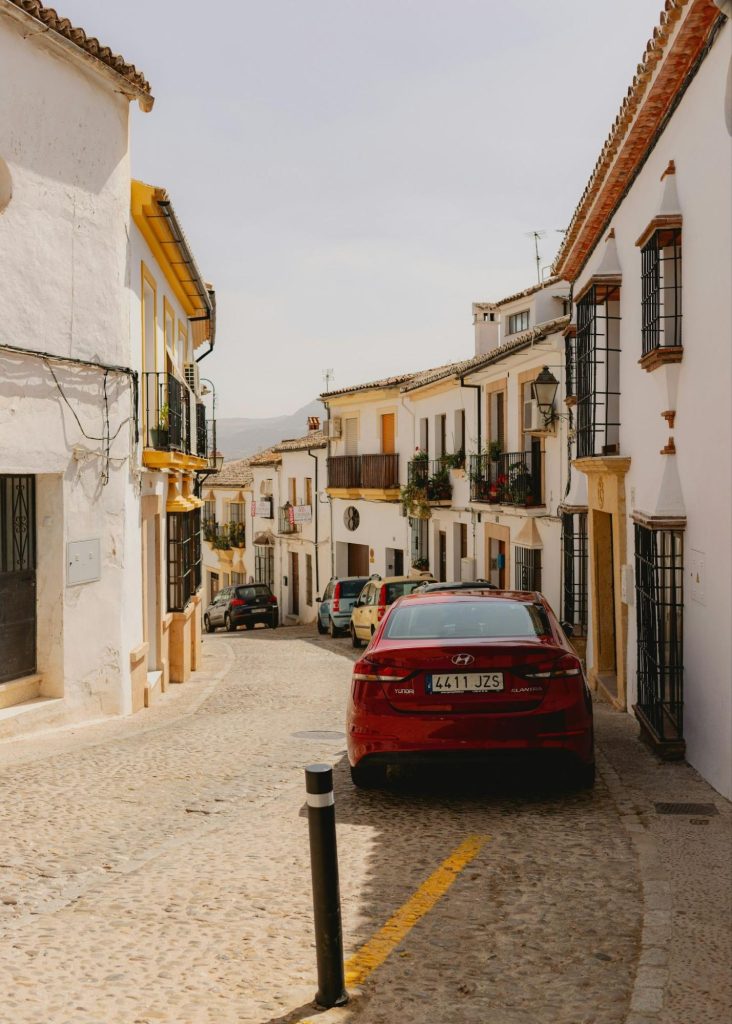 Car driving through a narrow Spanish village street