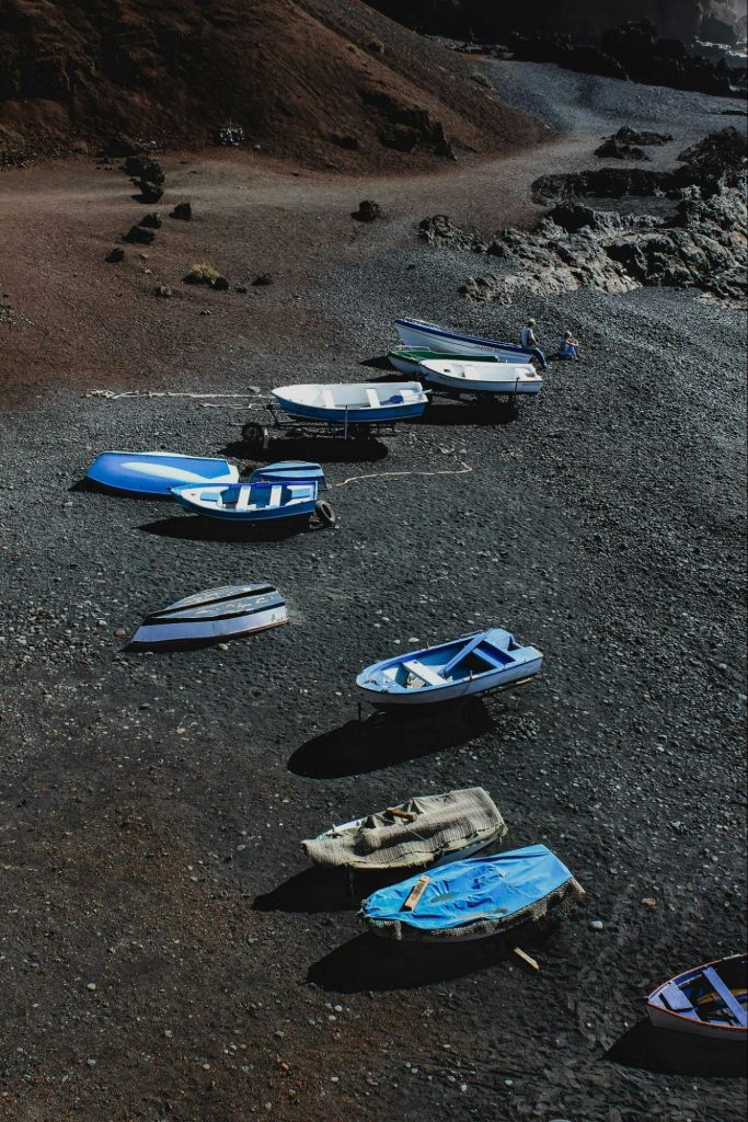 Small boats resting on a volcanic island shore