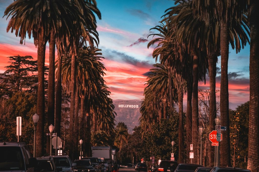 Hollywood Sign view through palm lined Los Angeles street at sunset