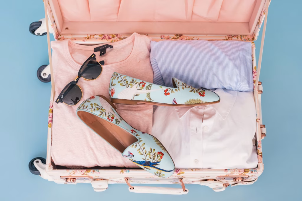 Organized suitcase with clothes, shoes, and sunglasses