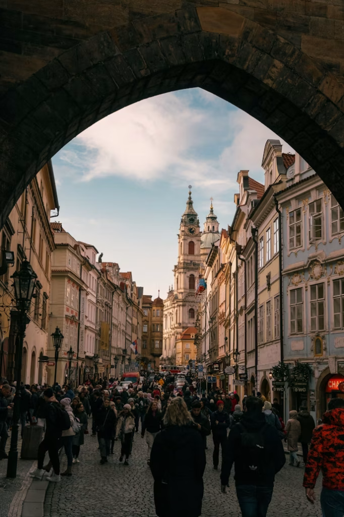 Busy Prague Old Town street with St. Nicholas Church tower